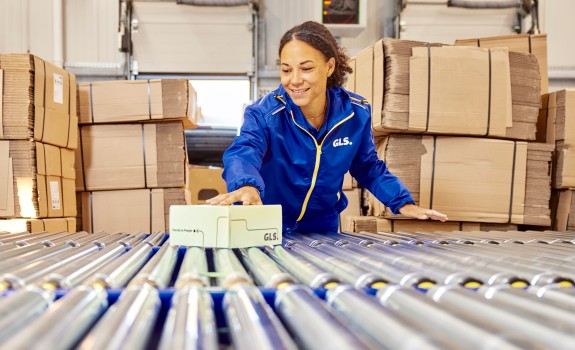 Mitarbeiterin im Depot mit Paket