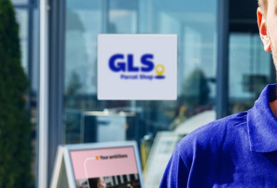 GLS courier with a parcel and handscanner in the street