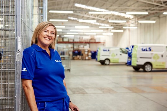 Zakenman in een depot met pakketten en palletten