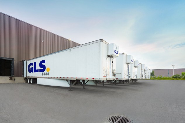 White GLS trailers docked at a warehouse.