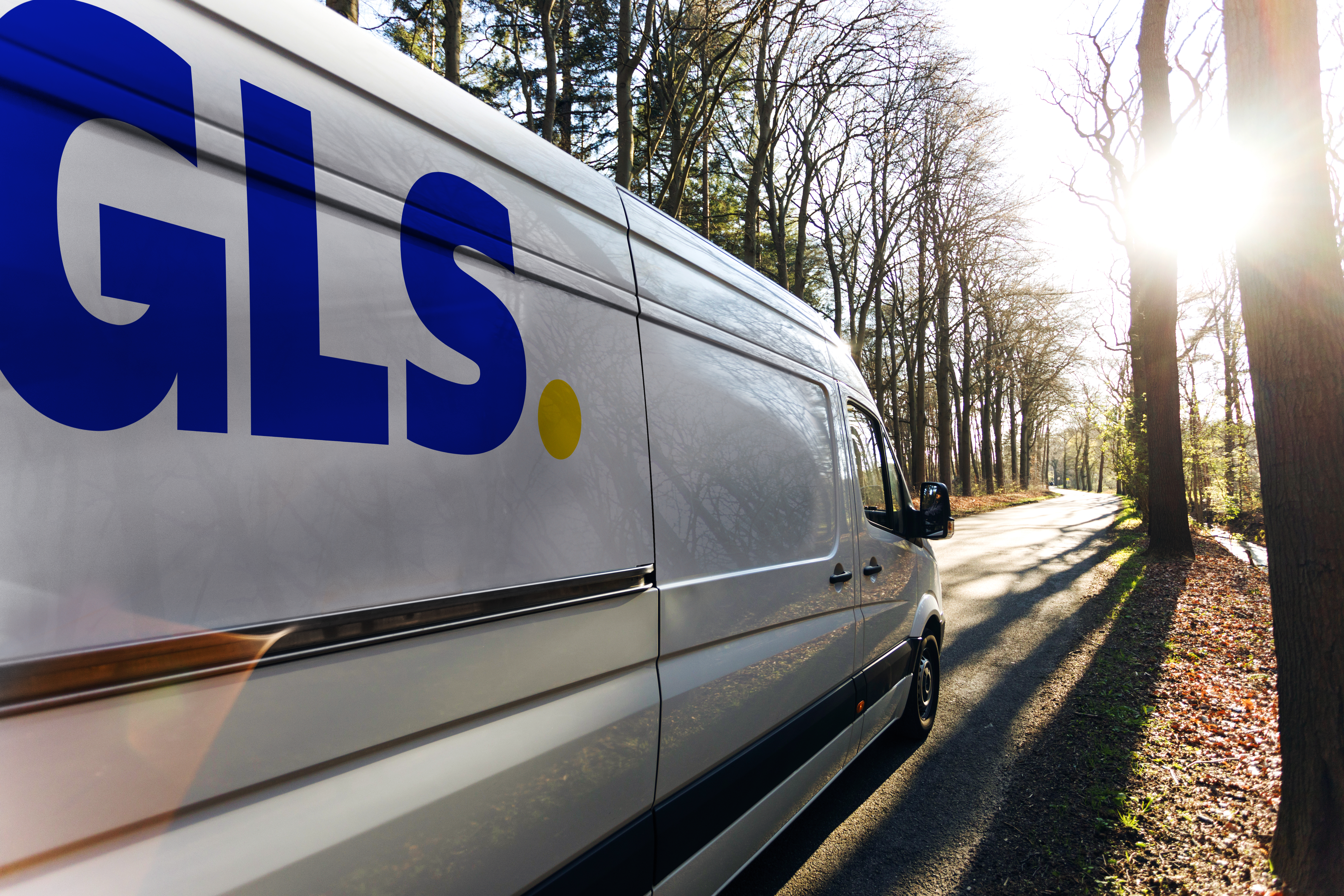 White GLS Parcel van driving through a forest.