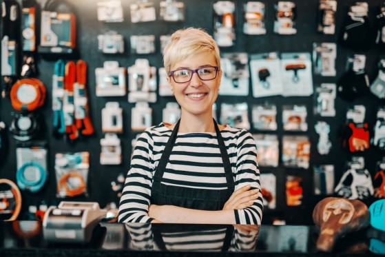 GLS business customer standing in front of her store and smiling towards camera