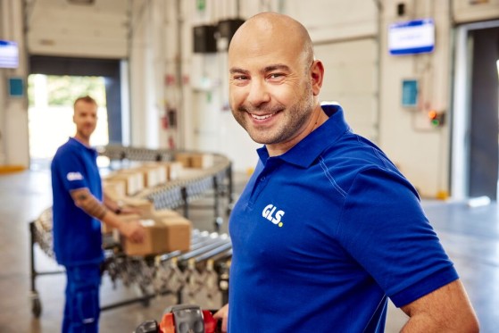 GLS employees standing next to the parcel conveyor