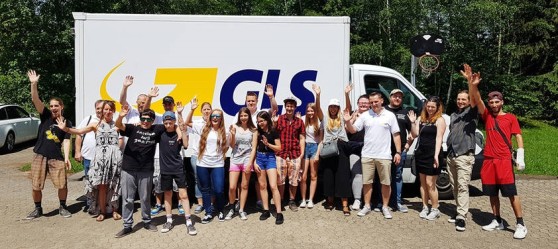 Crowd of children cheers in front of a GLS delivery van