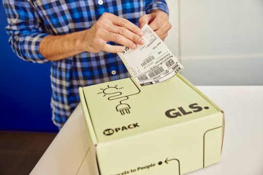 GLS employee labeling a parcel before redelivery, representing the Excellence Lab's process of identifying and rerouting lost packages to the correct address