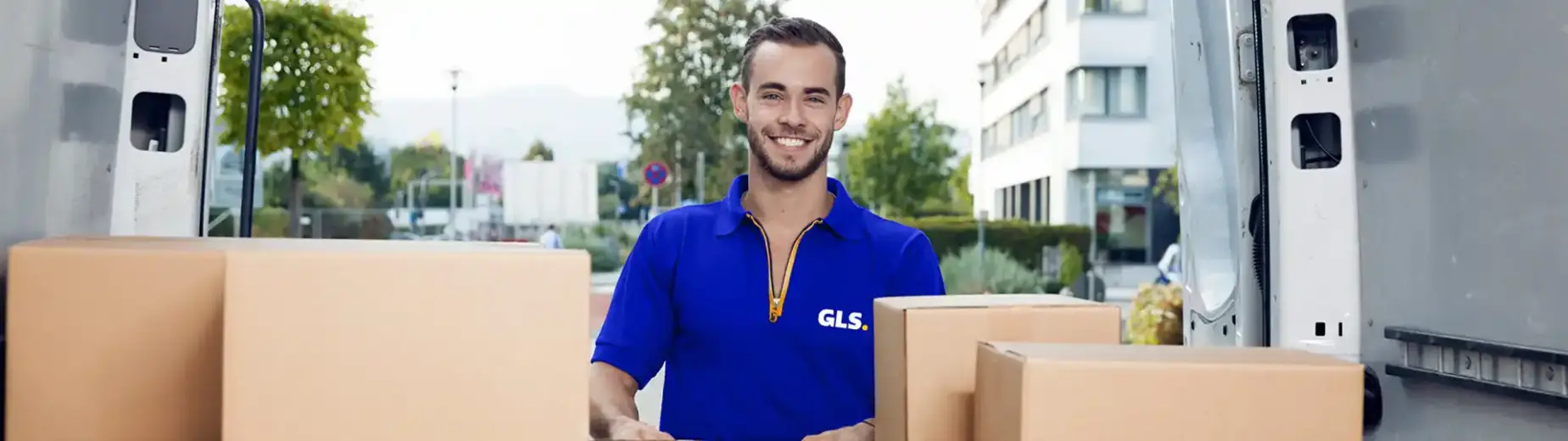 smiling GLS France driver unloading parcel at the back of the truck