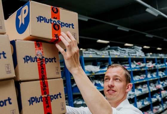 Medewerker Plutosport pakt een pakket