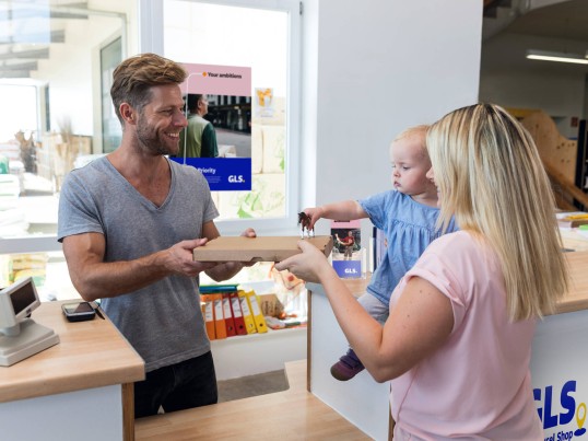 Happy Customer picks up her parcel in Parcel Shop