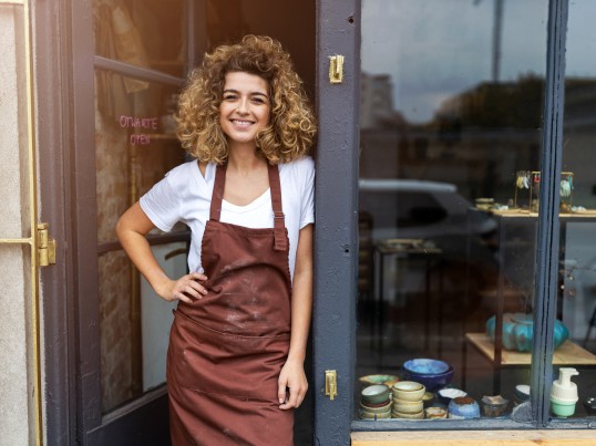 smiling girl in GLS ParcelShop is waiting for the international parcel