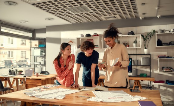 3 angajați tineri lucrând împreună la un proiect 