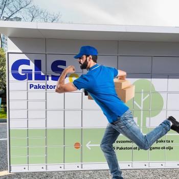 GLS deliveryman runing with parcel infront of parcel locker